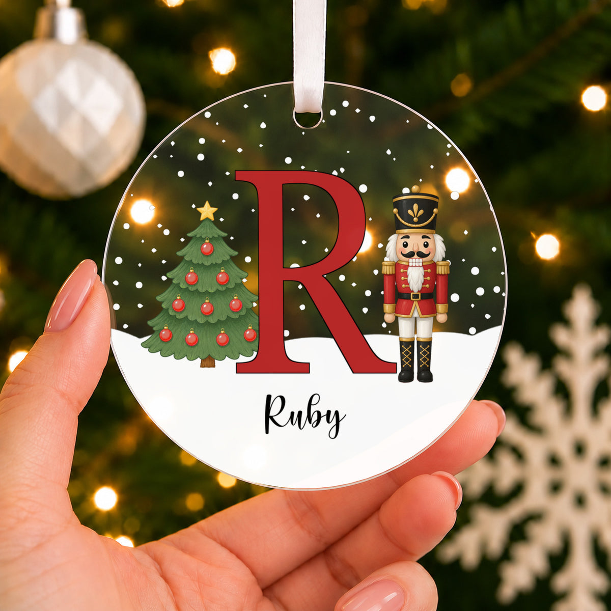 Personalised Nutcracker Initial Christmas Bauble – Pink, Blue or Red Letter – shown held in the hand