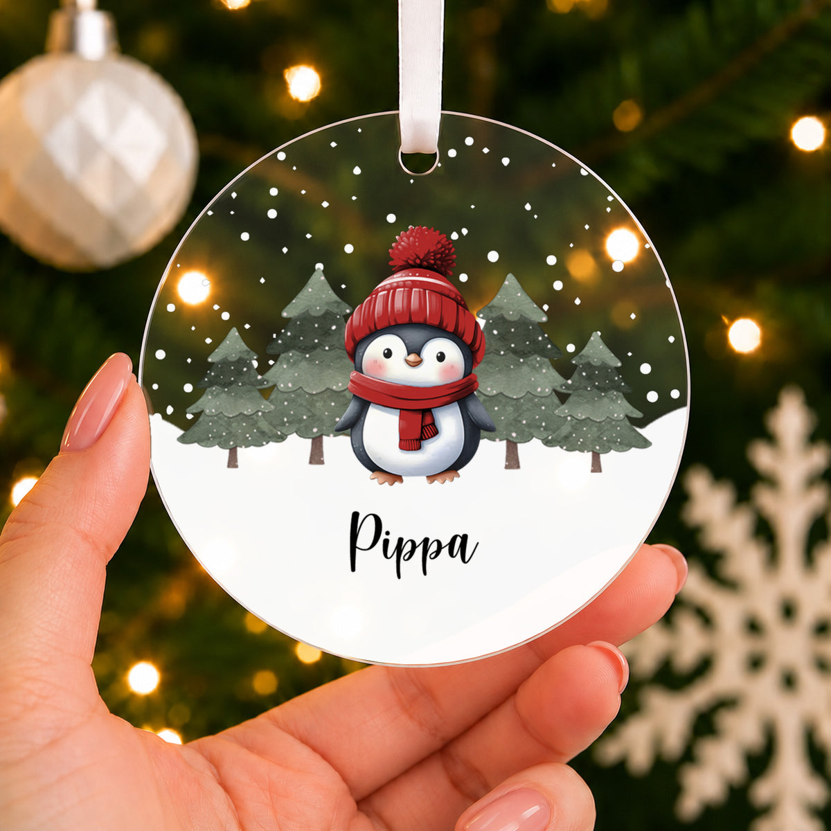 Personalised Penguin Christmas Bauble – Pink, Blue or Red with Name – shown held in the hand