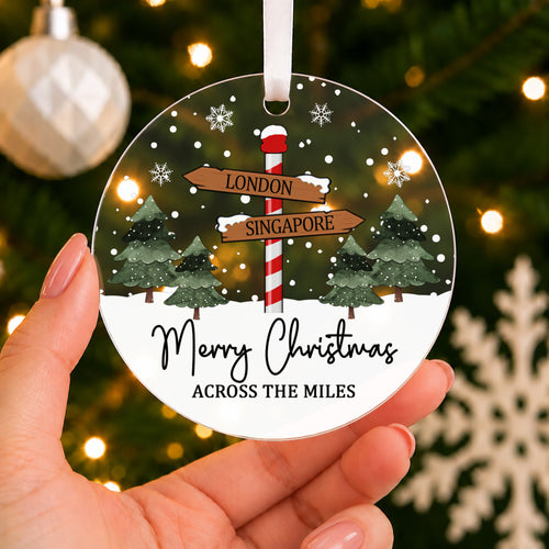 Personalised Across the Miles Christmas Bauble – Signpost Design – shown held in the hand
