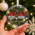 Personalised Special Couple Christmas Bauble – Santa Hats with Both Names – shown held in the hand
